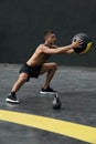 Sport man doing side lunge exercise with med ball at fitness gym Royalty Free Stock Photo