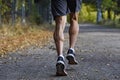 Sport man with ripped athletic and muscular legs running off road in jogging training workout at countryside in Autumn background Royalty Free Stock Photo