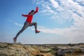 Sport man running, jumping over rocks in mountain area. Royalty Free Stock Photo