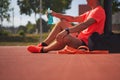 Sport man in sportive clothes relaxing after workout at the stadium, runner taking break after running sport. Royalty Free Stock Photo