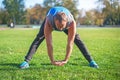 Sport man stretching at the park, doing exercises on grass. Fitness concepts