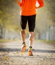 Sport man with strong calves muscle running outdoors in off road trail ground with trees under beautiful Autumn sunlight Royalty Free Stock Photo