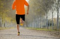 Sport man with strong calves muscle running outdoors in off road trail ground with trees under beautiful Autumn sunlight Royalty Free Stock Photo