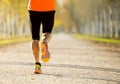 Sport man with strong calves muscle running outdoors in off road trail ground with trees under beautiful Autumn sunlight Royalty Free Stock Photo