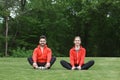 Sport man and woman meditating in park