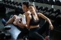 sport man and woman sitting on floor tired taking a break drinking water after exercise . workout. asian couple fitness in