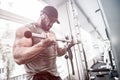 Sport motivation concept of powerful focus bearded man training his biceps muscles in sport gym