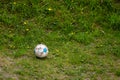 Sport. Old dirty soccer ball on grass. Football.