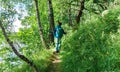 Sport orienteering in forest for kids. Boy traveler walks on a touristic hiking trail to a family tent camp on the shore of a fore Royalty Free Stock Photo