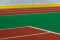 Sport, part of the playing field covered with red and green artificial turf with white markings and a white wall separated by a