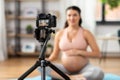 pregnant woman or yoga blogger with camera at home Royalty Free Stock Photo