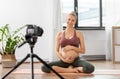 Pregnant woman or yoga blogger with camera at home Royalty Free Stock Photo