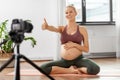 Pregnant woman or yoga blogger with camera at home Royalty Free Stock Photo