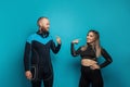 Sport people. Happy successful man and woman in fitness eguipment on blue background