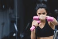 Sport, people and liefstyle concept. Horizontal close-up portrait of strong young woman doing exercise with dumbbells. Fitness