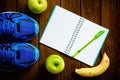 Sport shoes, Apples and bananas on a wooden background. Sport Royalty Free Stock Photo