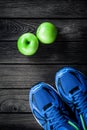 Sport shoes and apples on a wooden background. Sport equipment Royalty Free Stock Photo