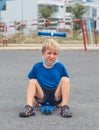 Sport squints freckled blond boy male child upset sad facial expressions, cunning funny mischievous, sit on kick scooter Royalty Free Stock Photo