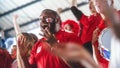 Sport Stadium Big Event: Handsome Expressive Black Man with Painted face Jumping Up and Cheering Royalty Free Stock Photo