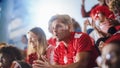 Sport Stadium Big Event: Handsome Man with Painted face Cheering. Crowd of Fans Shout for Red Soccer Royalty Free Stock Photo