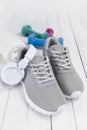 Sport symbols - gray sneakers, earphones, towel and dumbbells Royalty Free Stock Photo