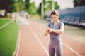 Sport and technology. beautiful young whiteskinned woman with ponytail at running stadium in front of workout uses a sporty smart