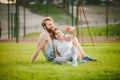 Sport and technology. Young in love heterosexual Caucasian couple resting after workout outdoors in park on lawn, green Royalty Free Stock Photo