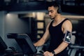 Sport Training. Young Arab Man Wearing Wireless Headphones Using Treadmill At Gym Royalty Free Stock Photo