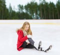 Young woman with knee injury on skating rink