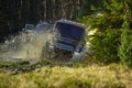 Sport utility vehicle or SUV crossing puddle with splash. Rallying, competition and four wheel drive concept. Motor Royalty Free Stock Photo