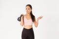 Sport, wellbeing and active lifestyle concept. Confused asian fitness girl in activewear looking puzzled, lifting Royalty Free Stock Photo