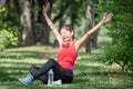 Sport woman breathing deeply fresh air with arms raised outdoor in urban park with blurred background Royalty Free Stock Photo