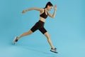 Sport woman with fit body jumping and running on blue background Royalty Free Stock Photo