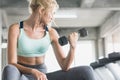 Sport woman lifting dumbbells weights focused exercise on her bicep for compact arm size Royalty Free Stock Photo