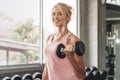 Sport woman lifting dumbbells weights focused exercise on her bicep for compact arm size Royalty Free Stock Photo