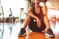 Sport woman relax resting after workout or exercise in fitness gym. Sitting and drinking protein shake or drinking water on floor Royalty Free Stock Photo