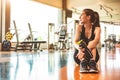 Sport woman relax resting after workout or exercise in fitness gym. Sitting and drinking protein shake or drinking water on floor Royalty Free Stock Photo