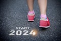 Sport woman runner foot shoe start into the new year 2024. Start up of runner woman running on nature race track go to Goal of
