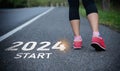 Sport woman runner foot shoe start into the new year 2024. Start up of runner woman running on nature race track go to Goal of