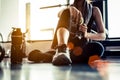 Sport woman sitting and resting after workout or exercise in fitness gym with protein shake or drinking water on floor. Relax Royalty Free Stock Photo