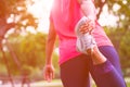 Sport woman stretching leg muscle preparing for running in the public park outdoor. Close up of female athlete lower body doing