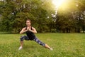 Sport woman wearing exercise suit doing stretching fitness exercise in city park at green grass Royalty Free Stock Photo