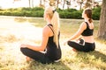 Sport women doing yoga outside in morning. Fitness girls relax in park