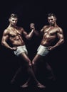 Sport workout for bodybuilder. Circus gymnasts at pilates or yoga training. Twins men with muscular body in balance pose