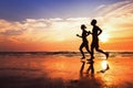 Sport and workout, silhouettes of people jogging at sunset beach Royalty Free Stock Photo