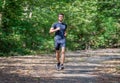 Sport young man running in the forest . runner exercise in nature Healthy lifestyle . training and workout Royalty Free Stock Photo