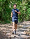 Sport young man running in the forest . runner exercise in nature Healthy lifestyle . training and workout Royalty Free Stock Photo