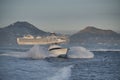 Sportfishing Boat hitting the waves in the ocean surrounded by mountains under a dark blue sky