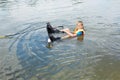 Sportin child riding on a wakeboard on the lake.