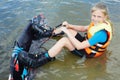 Sportin child riding on a wakeboard on the lake.